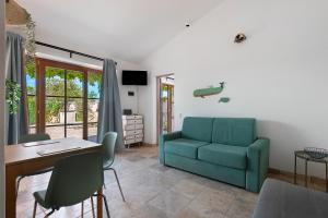 a living room with a blue couch and a table at Casa Kim - Capoliveri in Capoliveri