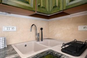 a kitchen with a sink and a faucet at Casa Kim - Capoliveri in Capoliveri +24 photos