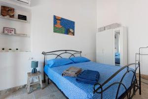 a bedroom with a bed with blue sheets and a suitcase on it at Casa Kim - Capoliveri in Capoliveri