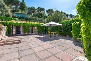 a patio with an umbrella and a table and chairs at Casa Kim - Capoliveri in Capoliveri
