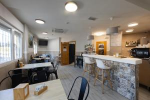 a restaurant with a bar and some tables and chairs at Hostal 82 in Olías del Rey