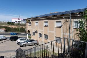 a group of cars parked in a parking lot next to a building at Hostal 82 in Olías del Rey