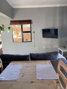 a living room with a couch and a wooden table at Pule's Home & Studio Apartments in Maseru