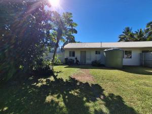 a house with a palm tree in front of it at Akaroa Hideaway in Avarua