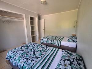 two beds in a small room withskirts at Akaroa Hideaway in Avarua