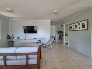 a living room with a couch and a tv on a wall at Akaroa Hideaway in Avarua