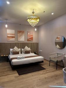 a bedroom with a large bed and a chandelier at Hotel KG Estate in Jaipur