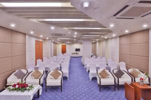 a conference room with white chairs and a podium at Avari Xpress Multan in Multan