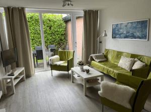 a living room with a green couch and chairs at Buitenplaats Herkingen 25-A in Herkingen