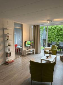 a living room with a couch and a tv at Buitenplaats Herkingen 25-A in Herkingen