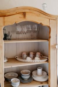 a shelf with dishes and glasses in a kitchen at Weinhof Narat-Zitz in Leutschach +26 photos