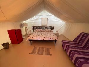 a bedroom with a bed and a chair in a tent at Glamping Agricampeggio Tognoni in La Sdriscia