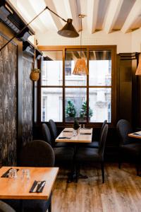 a restaurant with tables and chairs and a window at Les Initiés in Rouen