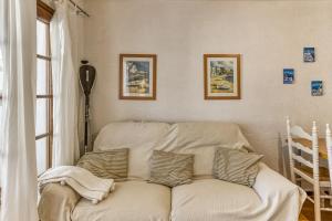 a living room with a white couch with pillows at Amarres con Piscina in L'Escala +19 photos