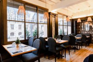 a restaurant with tables and chairs and large windows at Les Initiés in Rouen