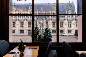 a table with christmas trees in front of a window at Les Initiés in Rouen