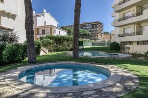 a swimming pool in the middle of a yard with trees at Amarres con Piscina in L'Escala