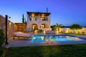 a villa with a swimming pool in front of a house at Deep Blue Villa in Lachania