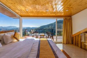 a bedroom with a bed and a large window at Vamitag Inn in Shimla