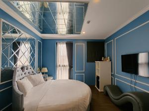 a bedroom with blue walls and a bed and a television at Min Boutique Hotel in Hà Ðông
