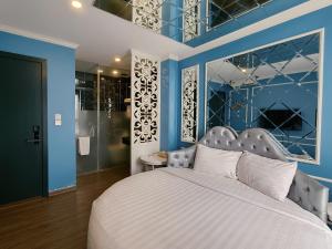 a bedroom with a large bed with blue walls at Min Boutique Hotel in Hà Ðông