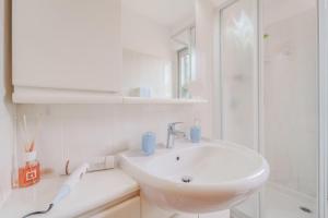 a white bathroom with a sink and a shower at Marina Vip Anna in Procchio