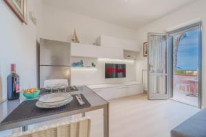 a kitchen with a counter with a table and a tv at Marina Vip Anna in Procchio