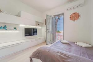 a white room with a bed and a tv at Marina Vip Anna in Procchio