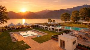 Luftaufnahme eines Ferienortes mit See und Bergen in der Unterkunft Seven Park Hotel Lake Como - Adults Only in Colico