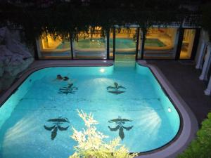 a pool with people swimming in it at night at Hotel & Spa Fontenay in Bad Wörishofen
