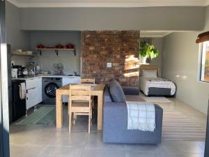 a living room with a couch and a table and a kitchen at Pule's Home & Studio Apartments in Maseru