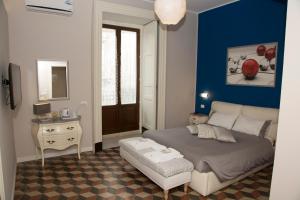 a bedroom with a bed and a blue wall at B&B Suite Cutelli in Catania