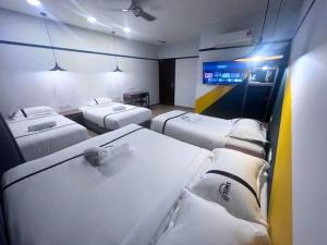 a room with four beds and a tv in it at Smile Hotel Damansara Tropical in Petaling Jaya