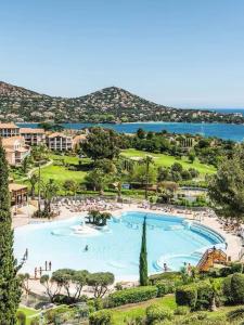 a large swimming pool in a resort next to the water at Magnifique vue mer - 2 pièces climatisé avec terrasse à Cap Estérel in Saint-Raphaël