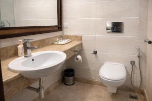a bathroom with a sink and a toilet at EMBLEM Hotel - Arjun Marg, Golf Course Road, Gurgaon in Gurgaon +36 photos