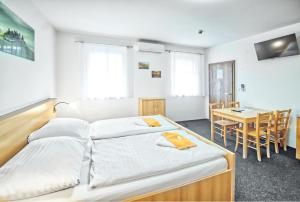a bedroom with two beds and a table and a dining room at U Jeřába - komplex A in Horní Věstonice +43 photos