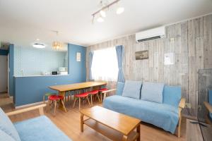 a living room with a blue couch and a table at 古宇利島まで車で10分の星降るやんばるテラス海まで徒歩3分のは1棟貸 in Nago