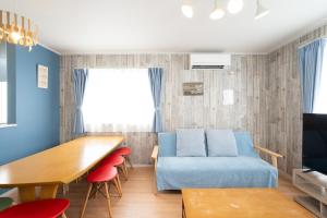 a living room with a blue couch and a table at 古宇利島まで車で10分の星降るやんばるテラス海まで徒歩3分のは1棟貸 in Nago