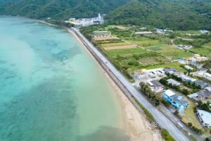an aerial view of a beach next to the ocean at 古宇利島まで車で10分の星降るやんばるテラス海まで徒歩3分のは1棟貸 in Nago