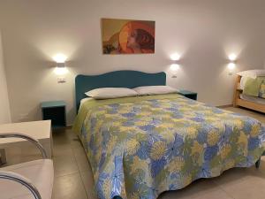 a bedroom with a bed with a blue and yellow bedspread at B&B Vento di Terra in Gaeta