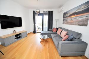 a living room with a couch and a flat screen tv at SeaWolf Apartment in Bečići