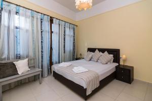 a bedroom with a bed and a window with curtains at George's Poet Maisonette in Rethymno Town