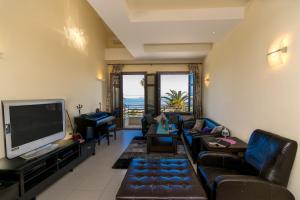 a living room with a couch and a television at George's Poet Maisonette in Rethymno