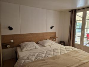 a bedroom with a large bed and a window at La Cabane de Nell in Lège-Cap-Ferret