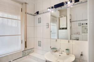 a white bathroom with a sink and a mirror at Casa Braun in Bonassola