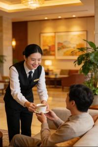 a woman handing a man a cup of coffee at 中青秋果酒店金边王宫店 True Go Hotel in Phnom Penh