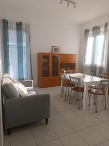 a living room with a couch and a table and chairs at Casa Tamerici in Marcelli