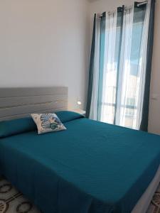 a bedroom with a blue bed with a window at Casa Tamerici in Marcelli