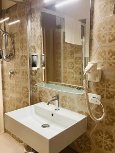 a bathroom with a white sink and a mirror at Maiolica in Trapani +48 photos