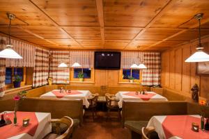 a restaurant with four tables and a tv on the wall at Hotel Alpenblick in Bach